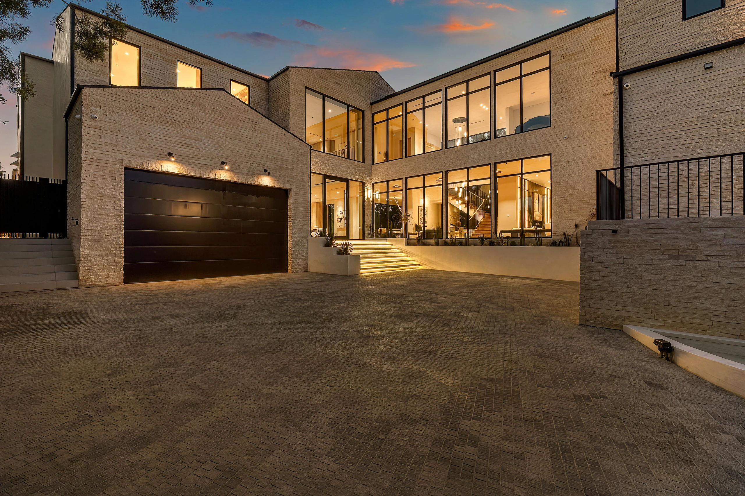 The front courtyard and glass entrance at dusk