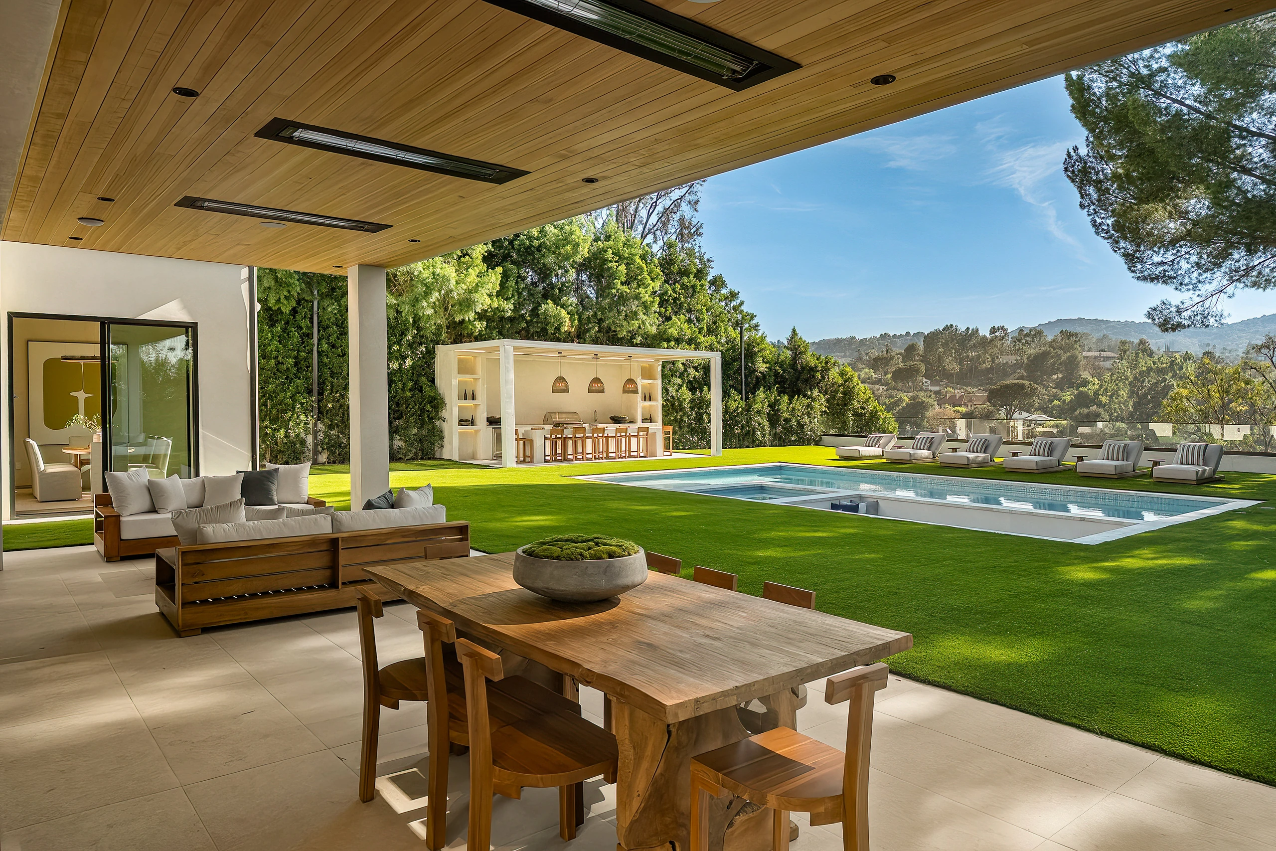The covered terrace overlooking the pool and lawn
