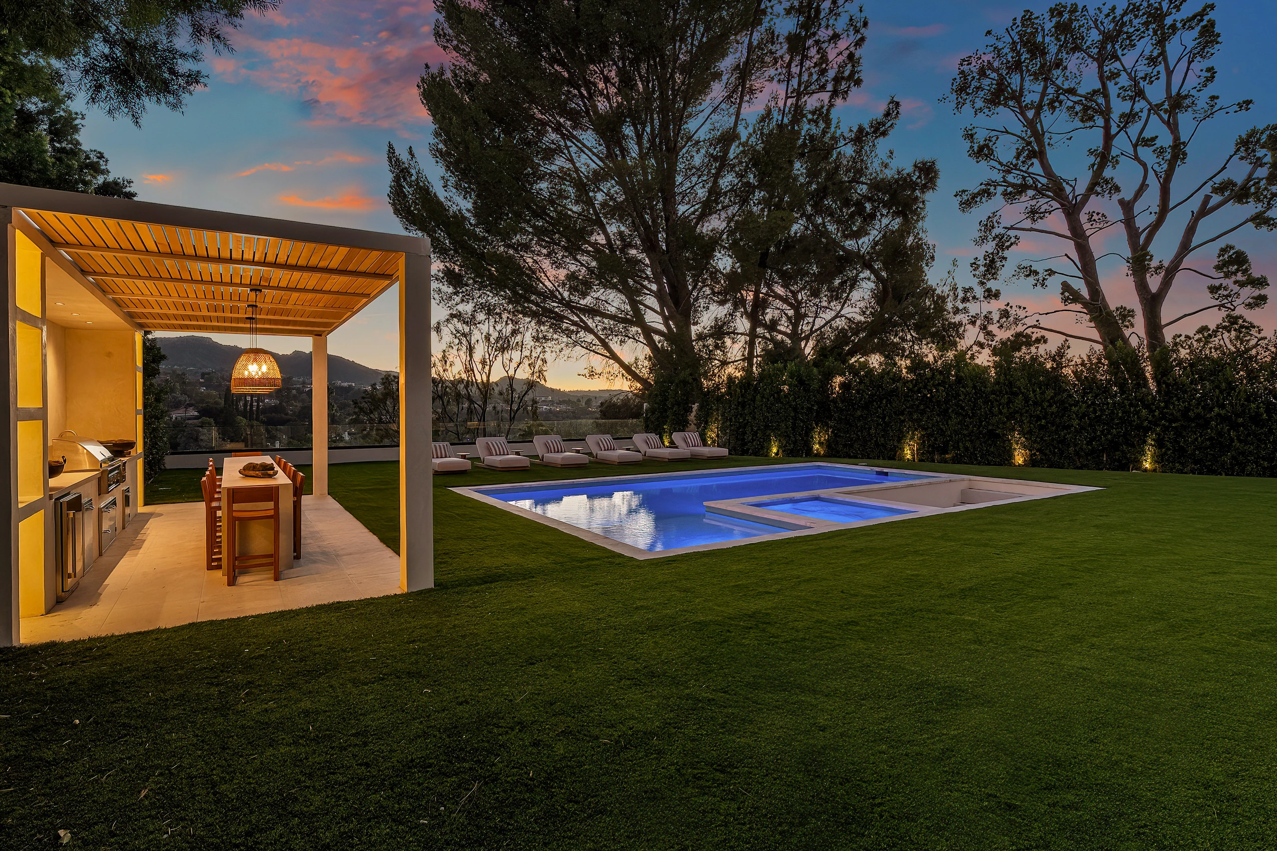 The covered outdoor bar and pool at dusk