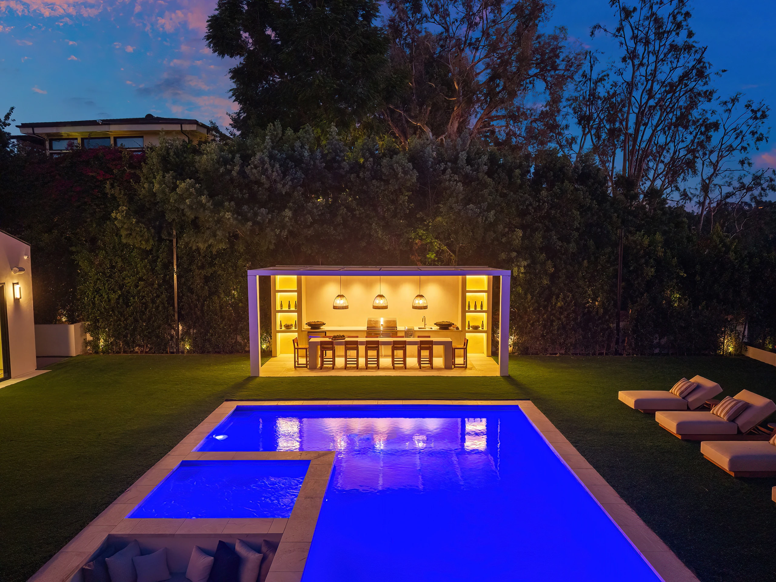 The illuminated pool and outdoor pavilion at night