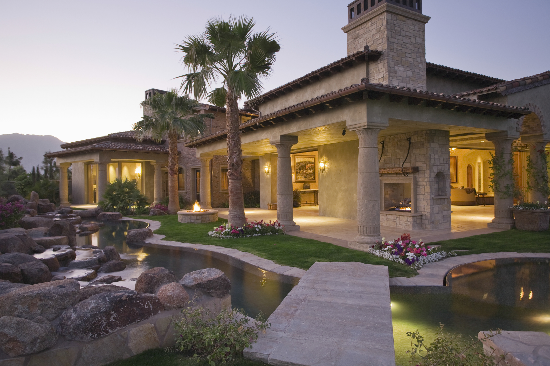 Illuminated House With Pond In Foreground