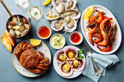 Seafood spread with oysters, shrimp, sauces, and garnishes on a dining table