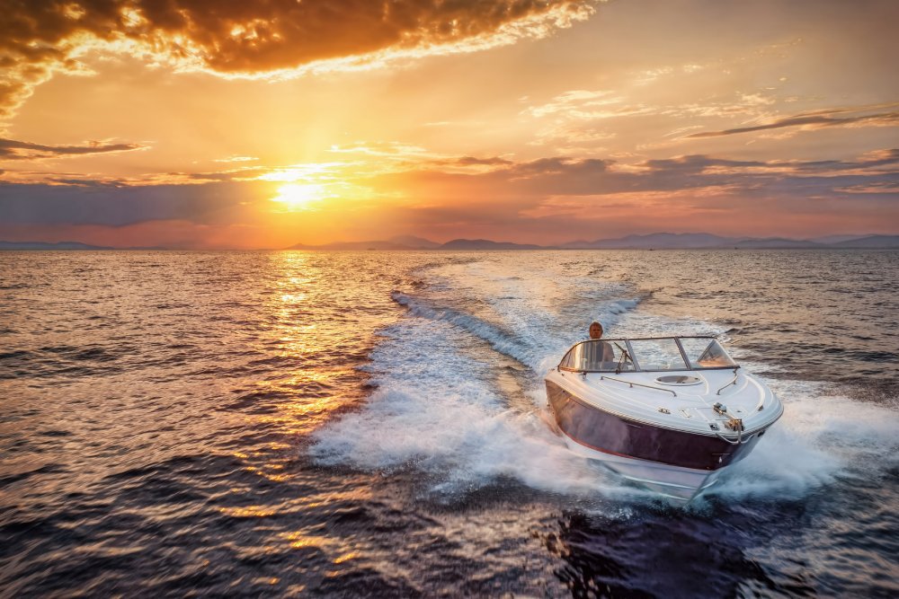 A motor speedboat cruising over the ocean during sunset time