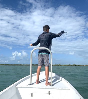 Fly fishing in belize, photo of a young man casting in belize