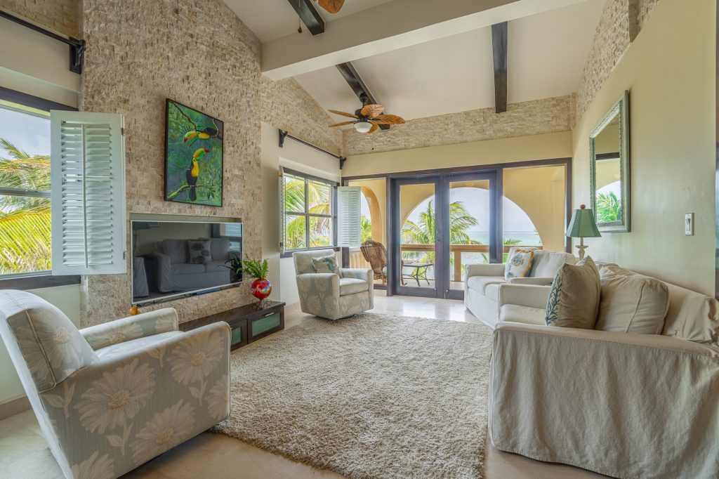 Ambergris Caye condo for sale with open-concept living area, ocean views, custom mahogany accents, and stone finish details at Serenity Shores