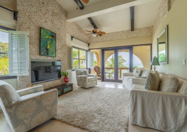 Ambergris Caye condo for sale with open-concept living area, ocean views, custom mahogany accents, and stone finish details at Serenity Shores