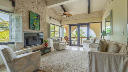 Ambergris Caye condo for sale with open-concept living area, ocean views, custom mahogany accents, and stone finish details at Serenity Shores