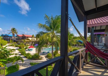 View from private balcony at X’tan Ha Resort showing beachfront pool, tropical gardens, and the Caribbean Sea on Ambergris Caye