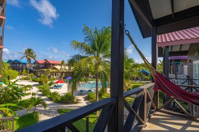 View from private balcony at X’tan Ha Resort showing beachfront pool, tropical gardens, and the Caribbean Sea on Ambergris Caye