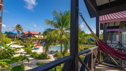 View from private balcony at X’tan Ha Resort showing beachfront pool, tropical gardens, and the Caribbean Sea on Ambergris Caye