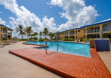 Garden-view Ambergris Caye condo at Royal Palm Villas with pool and direct beach access.
