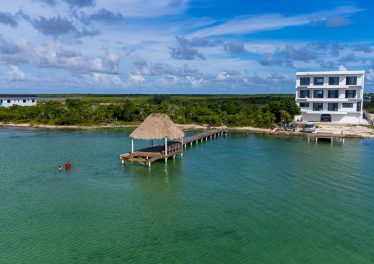 Aerial view of 0.2-acre beachfront property at Secret Beach, Ambergris Caye, showing road access and private pier