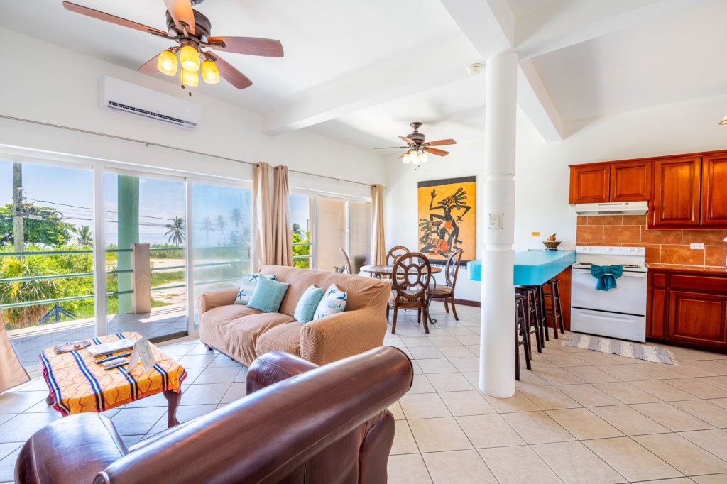 Living room of Mara Laguna condo with large windows overlooking the Caribbean Sea on Ambergris Caye, Belize.