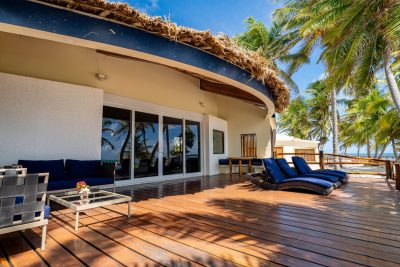 Villa Sapphire beachfront deck with lounge chairs and thatched roof at La Perla del Caribe resort, a luxury Belize beach house