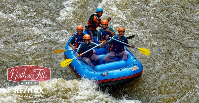 groupof people on a boat in the middle of wild river