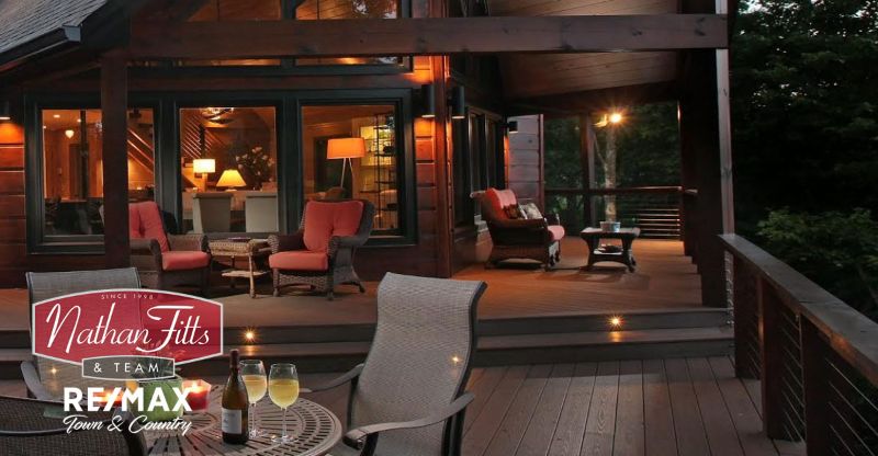 outside area of a house with glass of wine and two glasses on a table ad