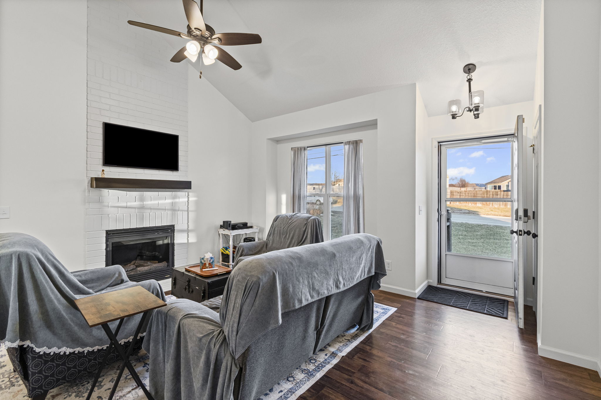 Vaulted living room with fireplace and dark wood floors