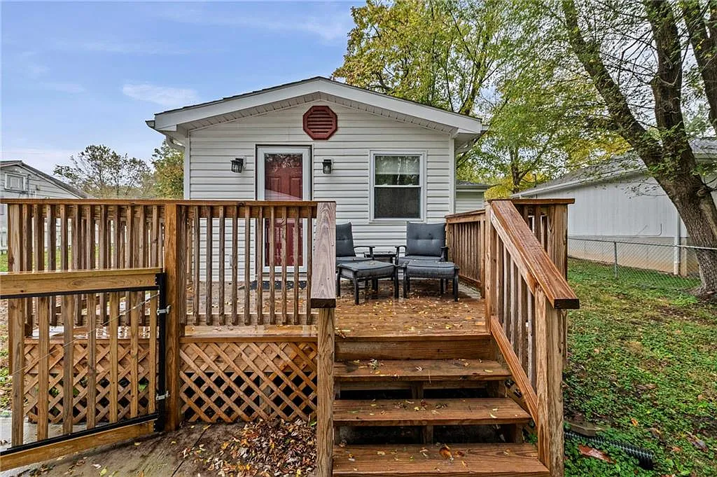 Out back: deck, covered patio, and the treed lot — 605 4th Street, Weston MO