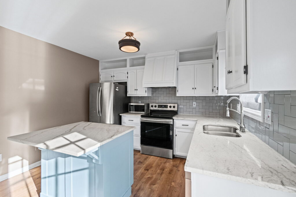 Updated kitchen with stainless appliances and island seating at 7205 N Hickory Street