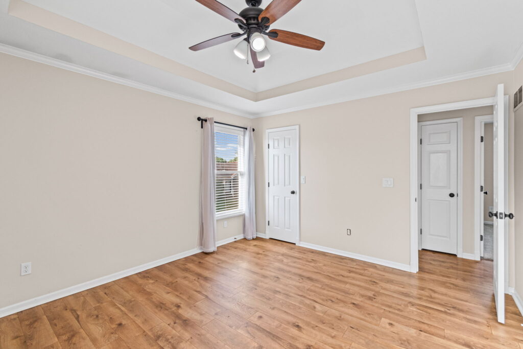 Primary suite with a tray ceiling, walk-in closet, and private bath at 7205 N Hickory Street