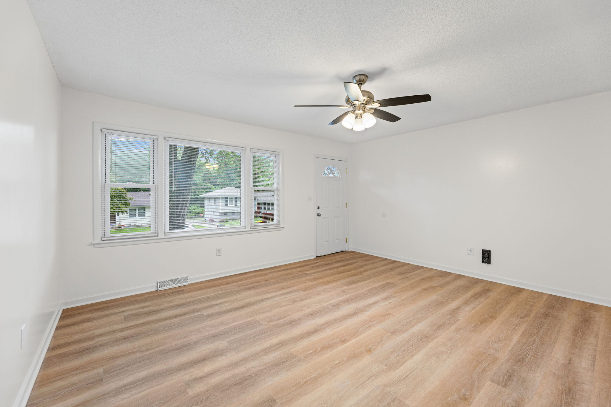 Bright living room with new flooring that carries through the main level — 119 Sherri Lane, Excelsior Springs, MO