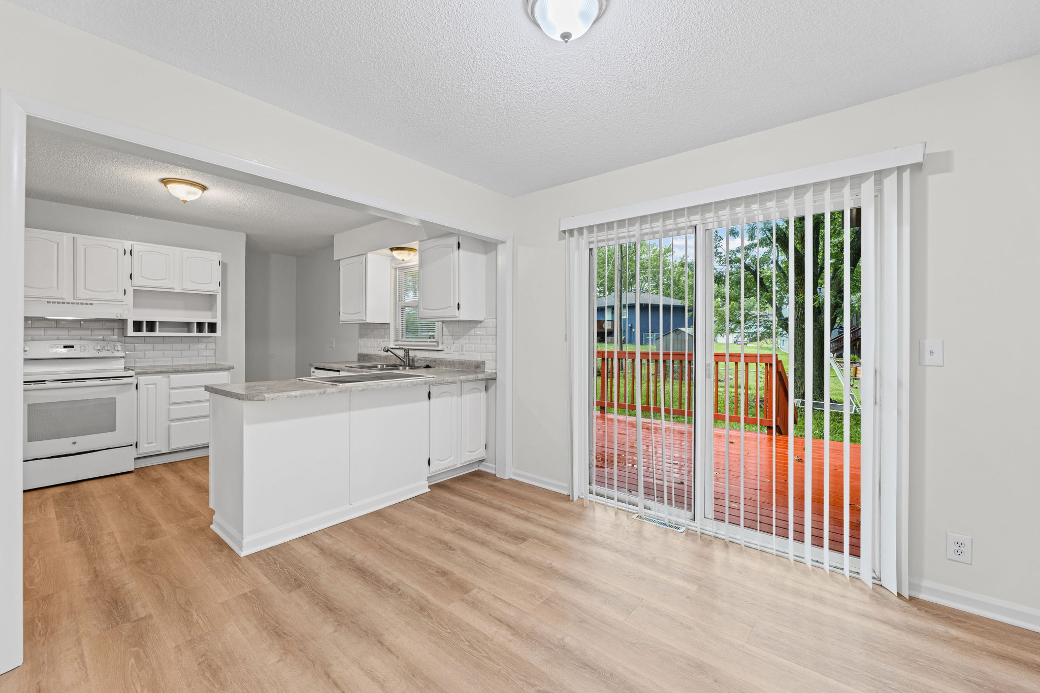 The breakfast bar opens to a slider out to the deck and backyard — 119 Sherri Lane, Excelsior Springs, MO