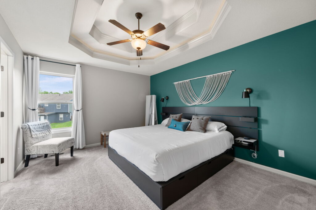 Main-floor primary bedroom with tray ceiling at 11907 N Tracy Avenue