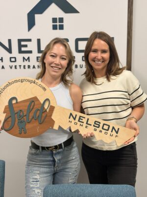 Kelly with Nelson Home Group agent Katy Gaines holding a SOLD key at the closing of 1700 Todd Street in Platte City