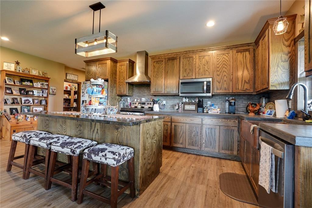 Kitchen with large island and stainless appliances at 114 SW 1451 Road, Holden, MO