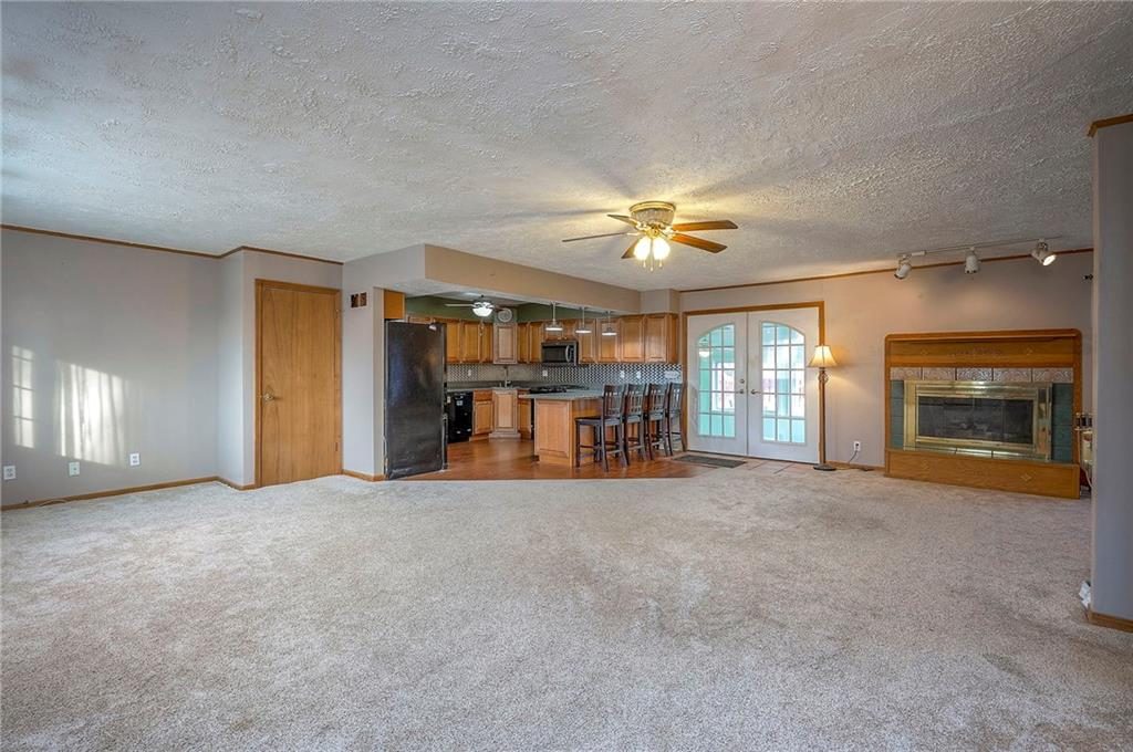 Newly carpeted living room opening to the kitchen at 6509 NW Twin Oaks Drive