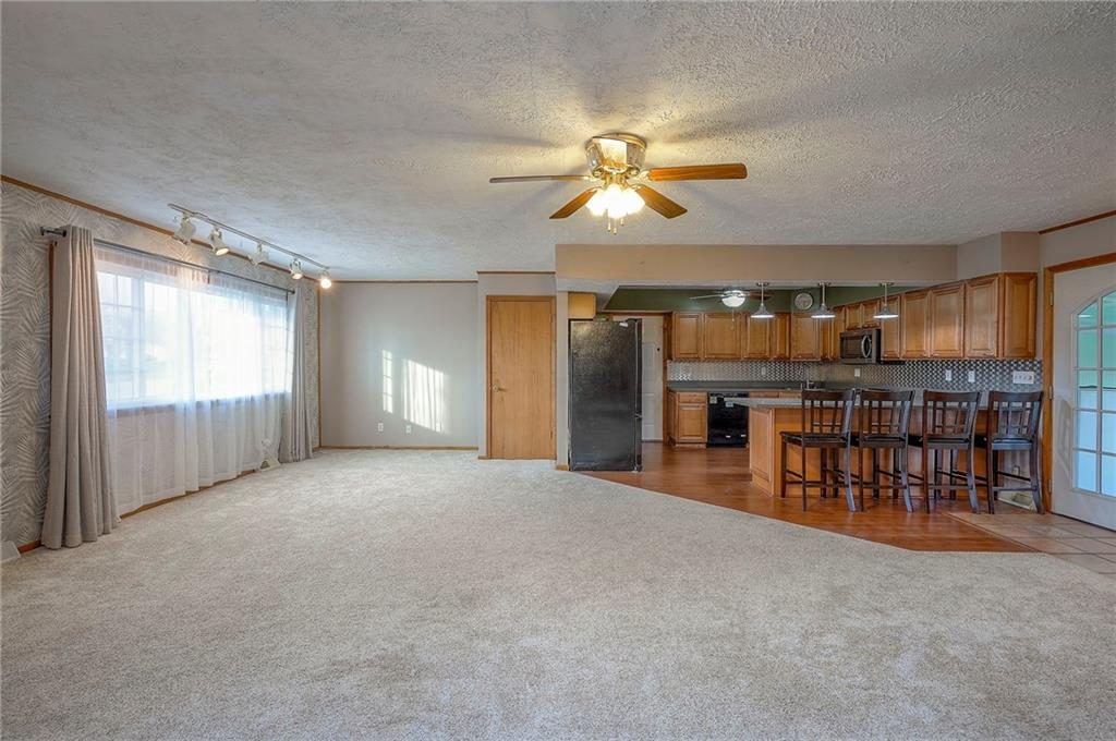 Living room with large windows at 6509 NW Twin Oaks Drive, Kansas City