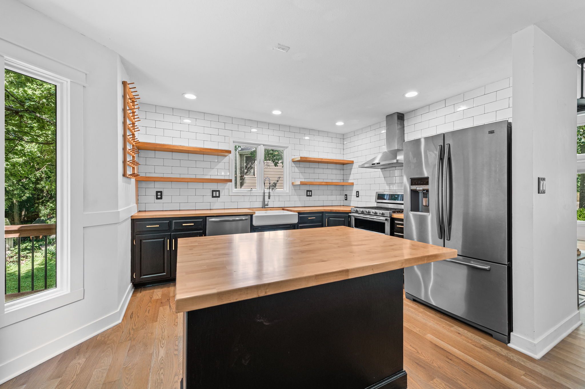 Updated kitchen with butcher block counters, open shelving and stainless appliances in a Platte City, Missouri home
