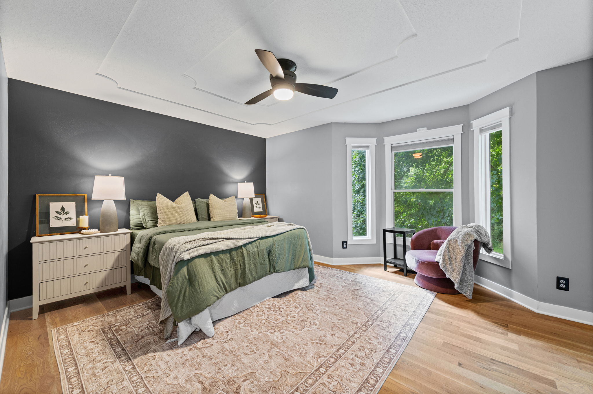 Primary bedroom with bay windows and a ceiling fan in a Platte City, Missouri home