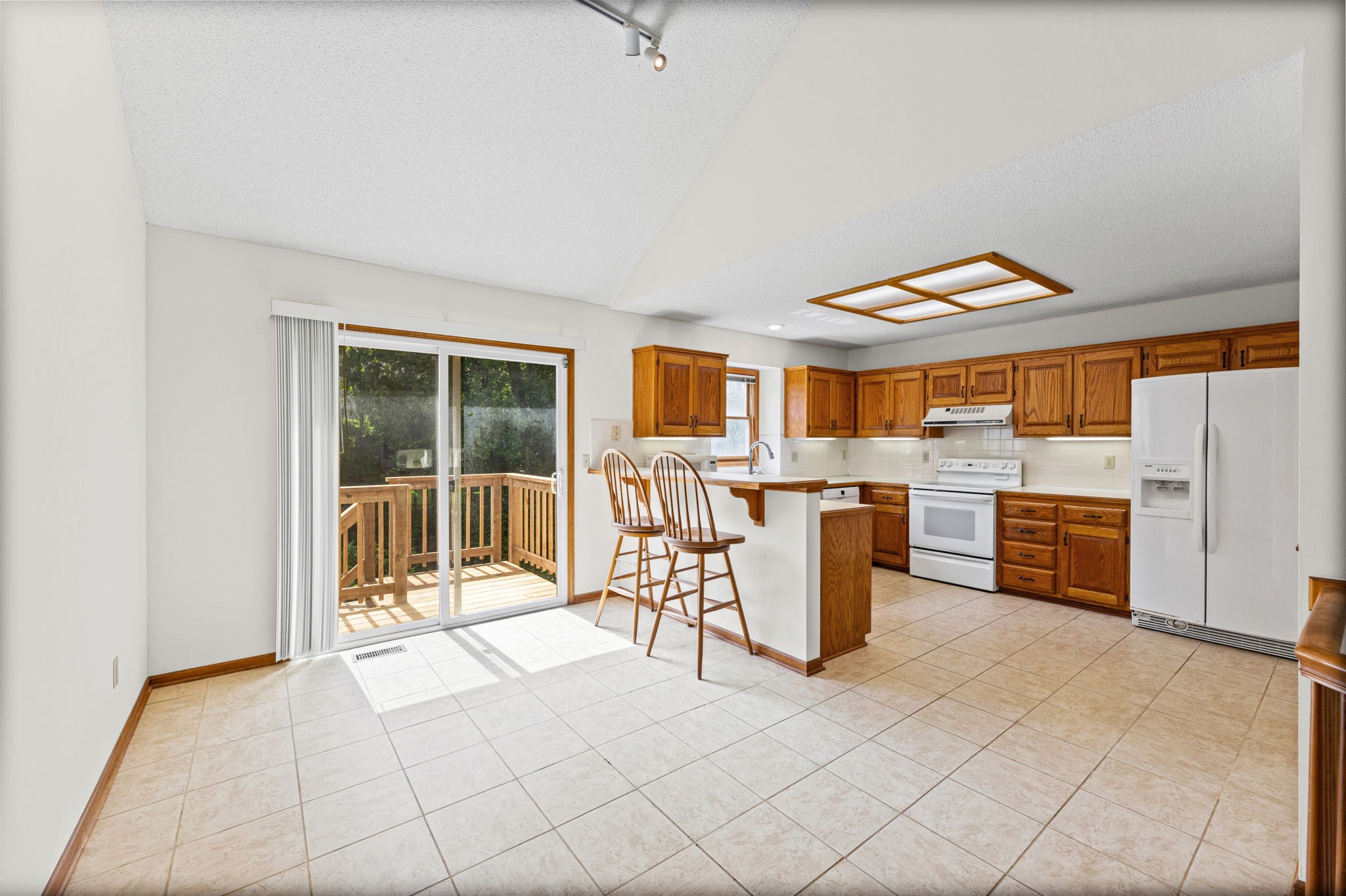 Eat-in kitchen with peninsula seating opening to the new back deck at 6409 Chouteau Street, Shawnee KS