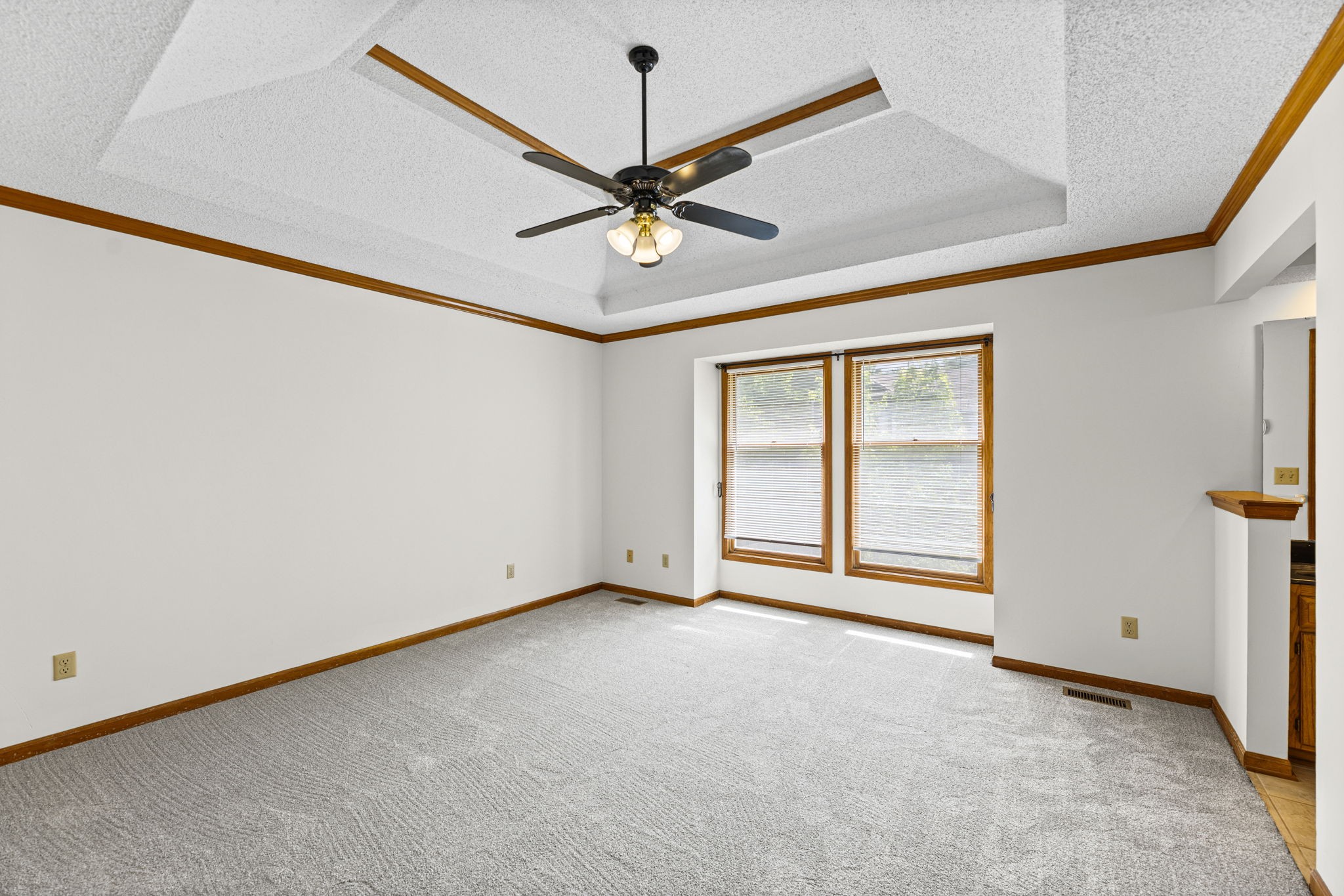 Primary suite with trey ceiling, ceiling fan, and two walk-in closets at 6409 Chouteau Street, Shawnee KS