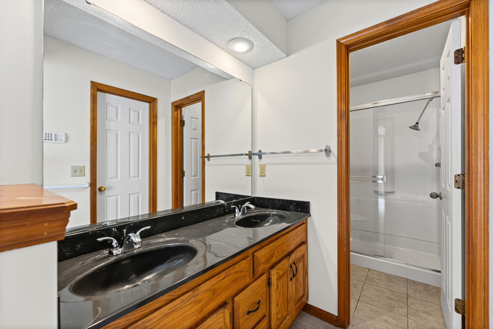 Primary bathroom with dual vanity and separate water closet at 6409 Chouteau Street, Shawnee KS
