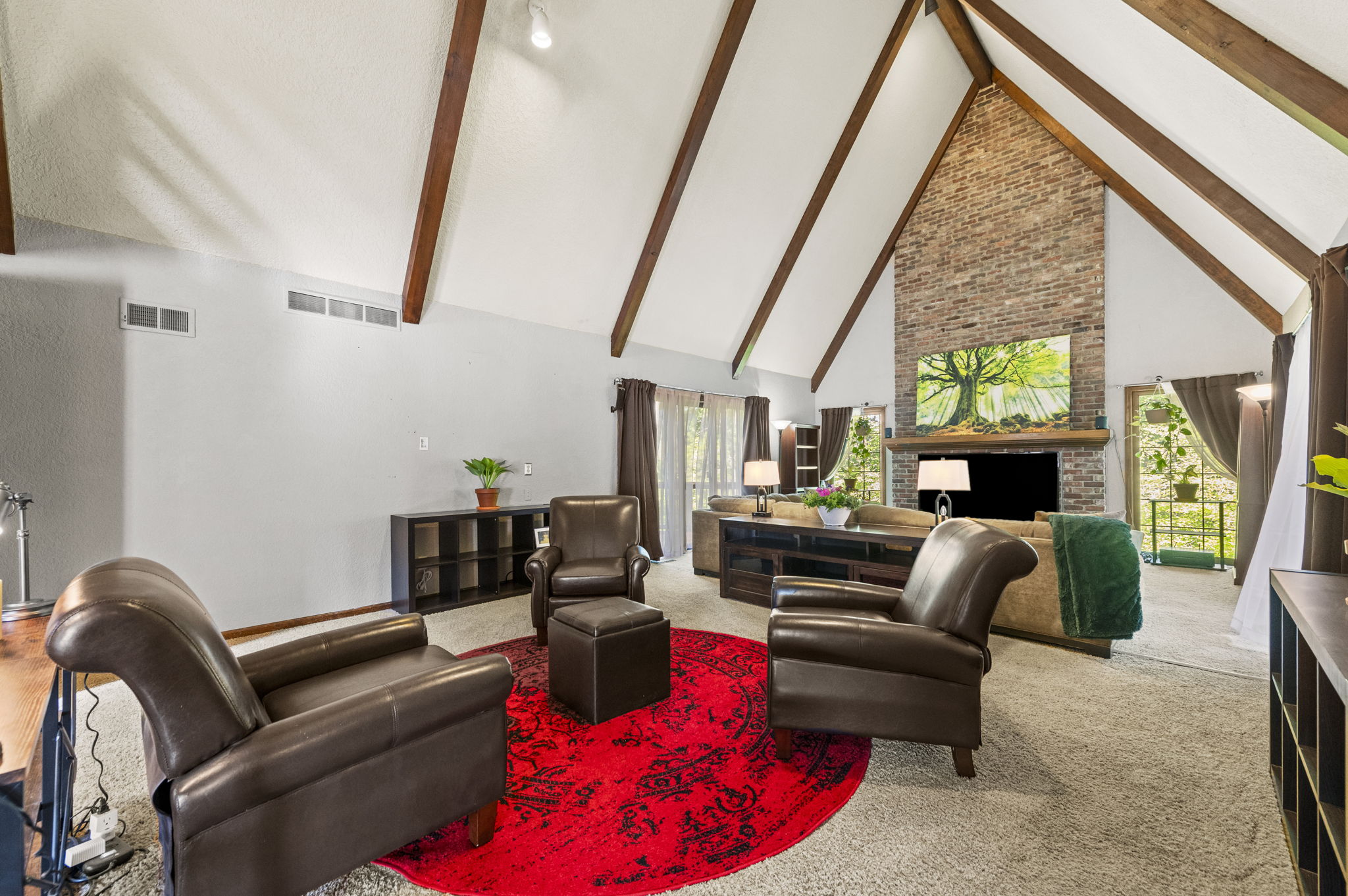 Vaulted great room with a floor-to-ceiling brick fireplace and walls of glass at 616 NW 42nd Terrace in Claymont