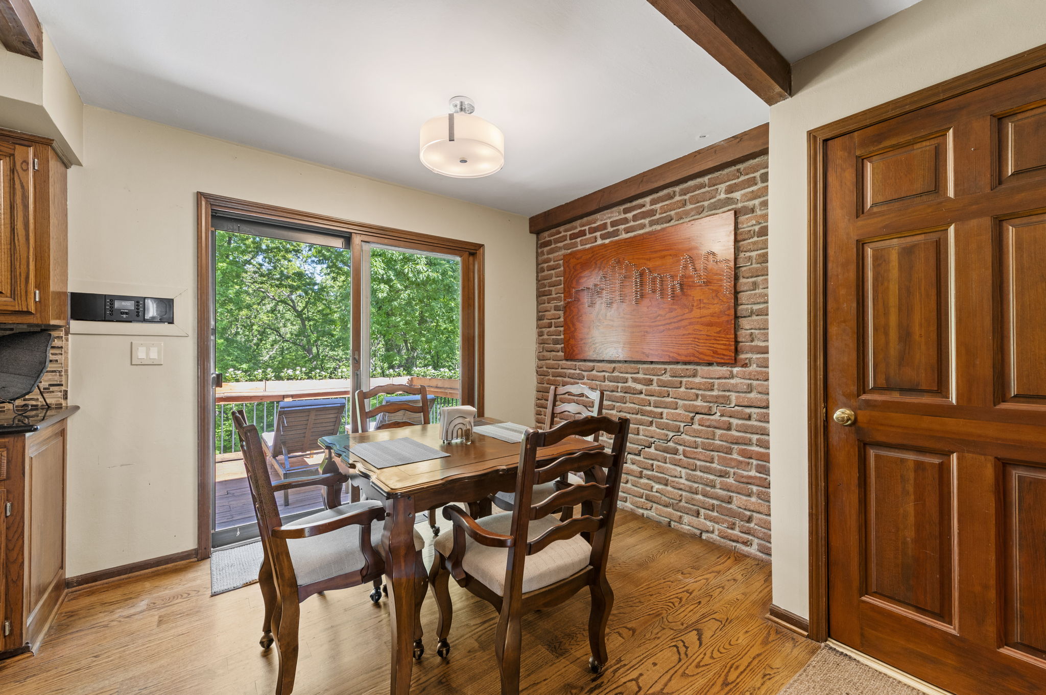 Breakfast room with a brick accent wall and windows to the wooded lot