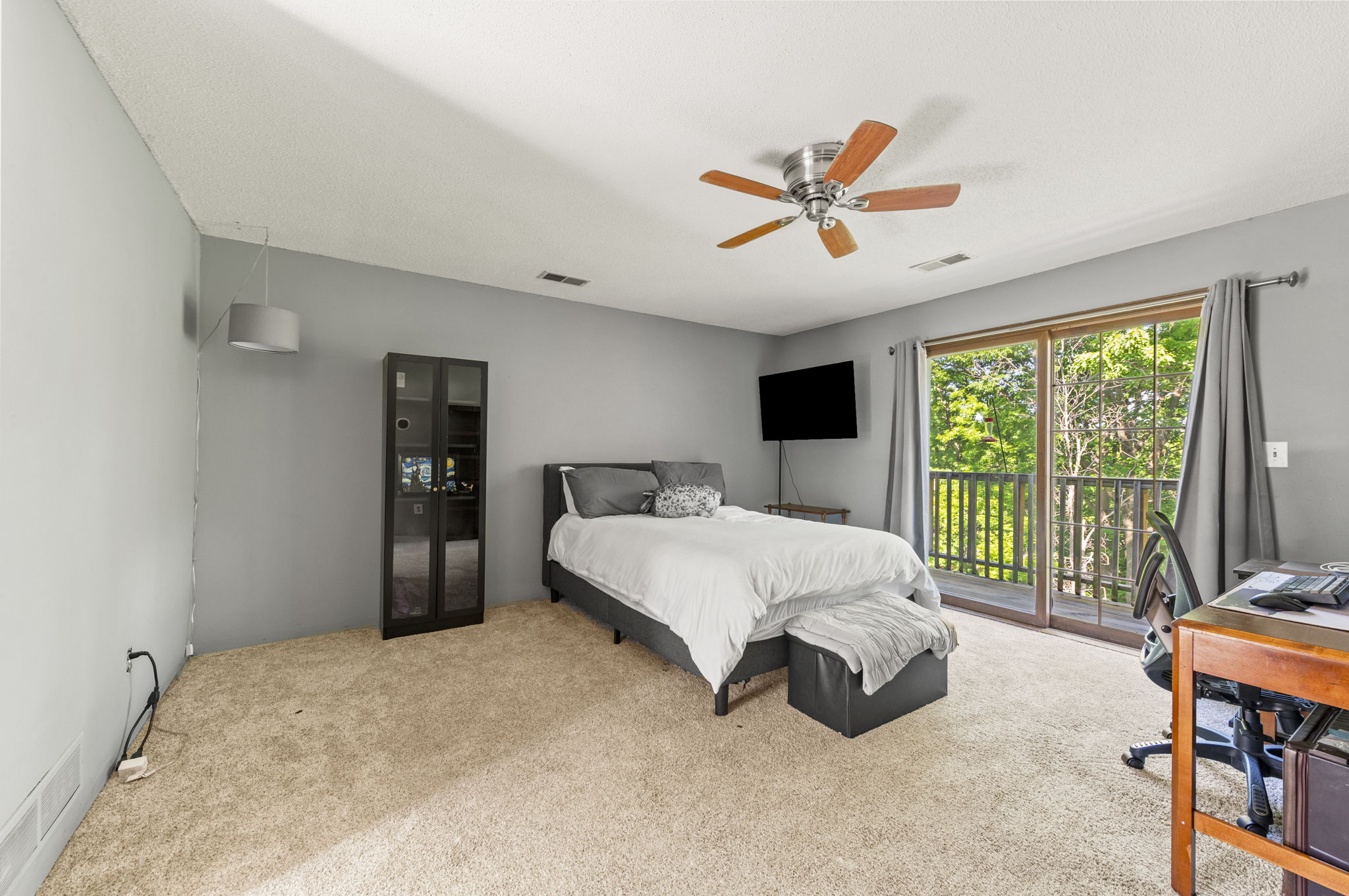 Upper-level bedroom with a vaulted ceiling and private deck access