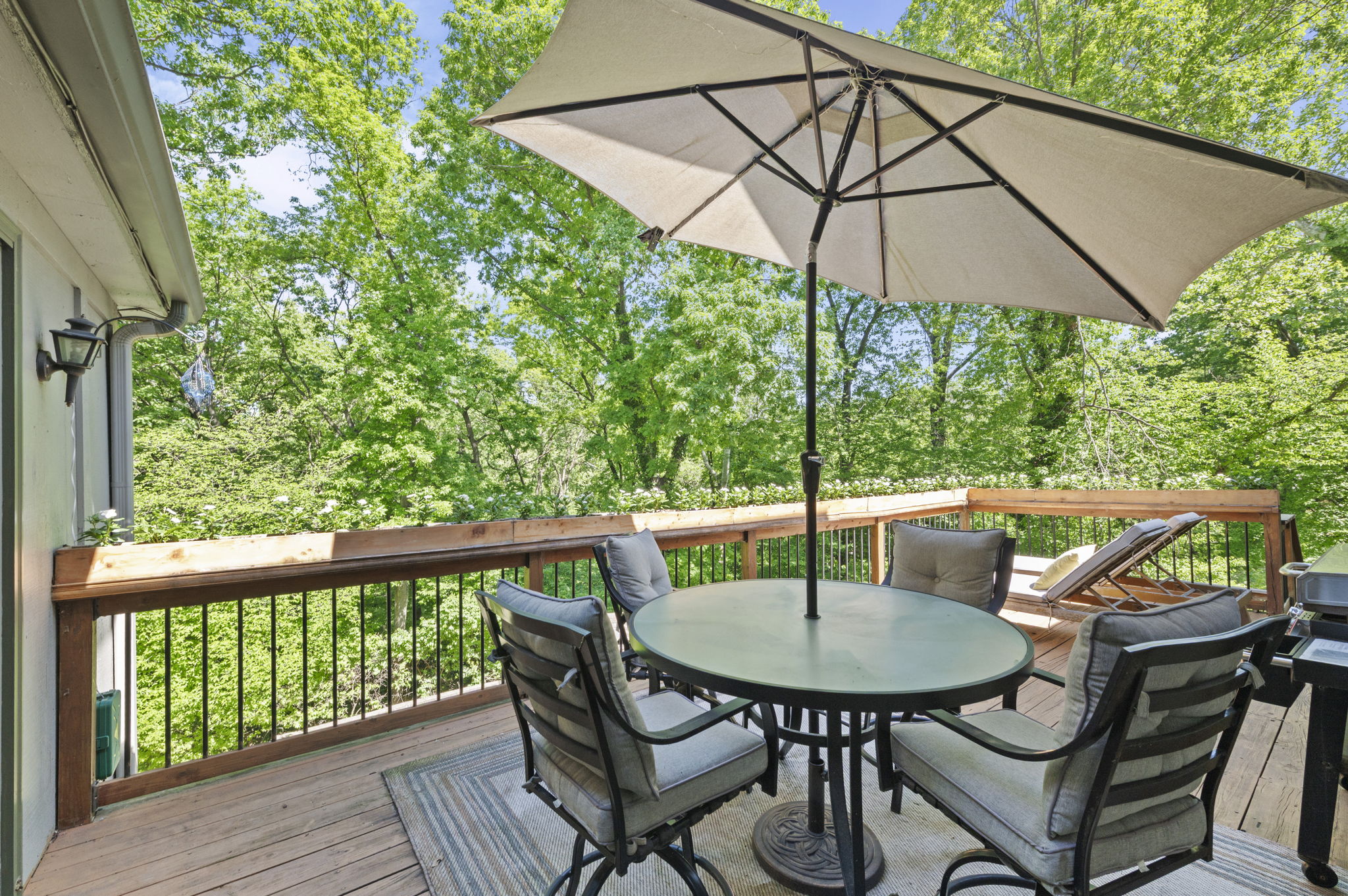 Wraparound deck with a covered dining area overlooking the trees