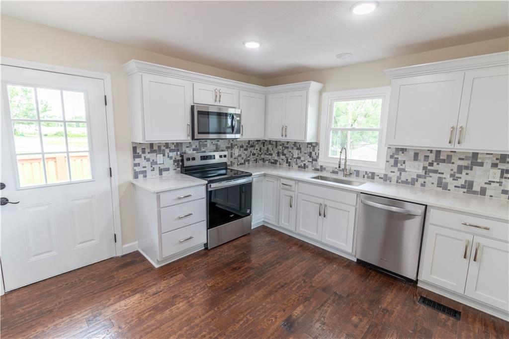 Brand-new kitchen with quartz countertops, tile backsplash and stainless appliances at 200 Cherry Street, Maysville, MO