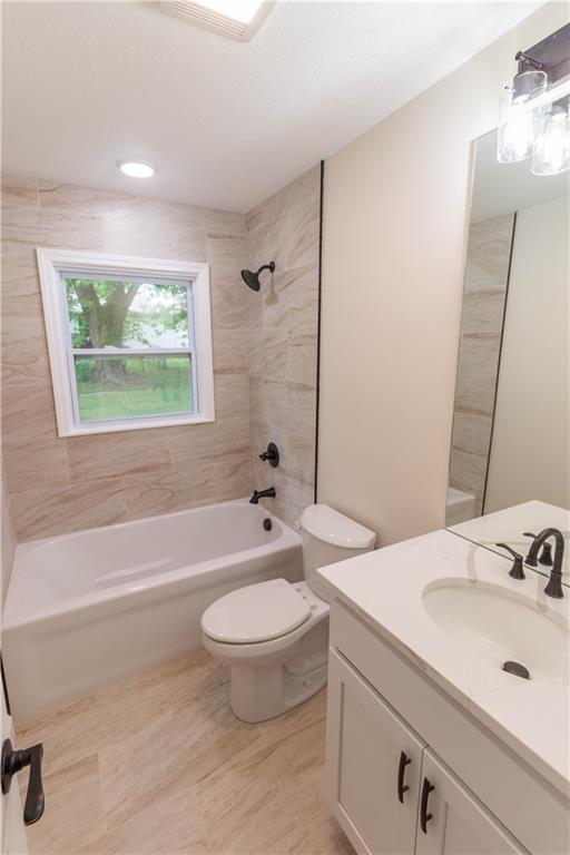 Full bathroom with tiled tub-shower and new vanity at 200 Cherry Street, Maysville, MO
