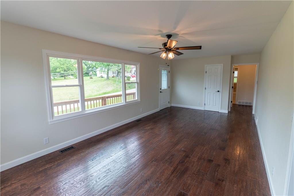 Living room with solid wood floors and large picture window at 200 Cherry Street, Maysville, MO