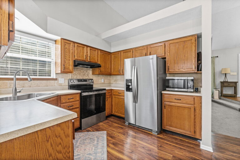 Kitchen with stainless steel refrigerator and tile backsplash at 1126 E Charlotte Town Road, Olathe, KS