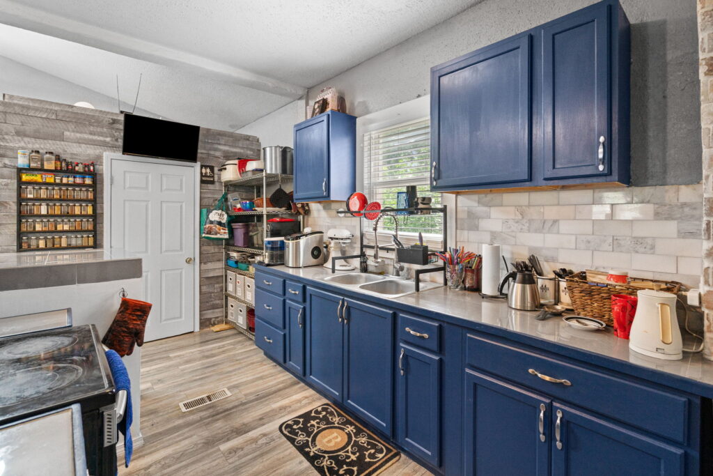 Kitchen with navy blue cabinets, stainless counters and a subway tile backsplash in a Kansas City, Missouri rental home