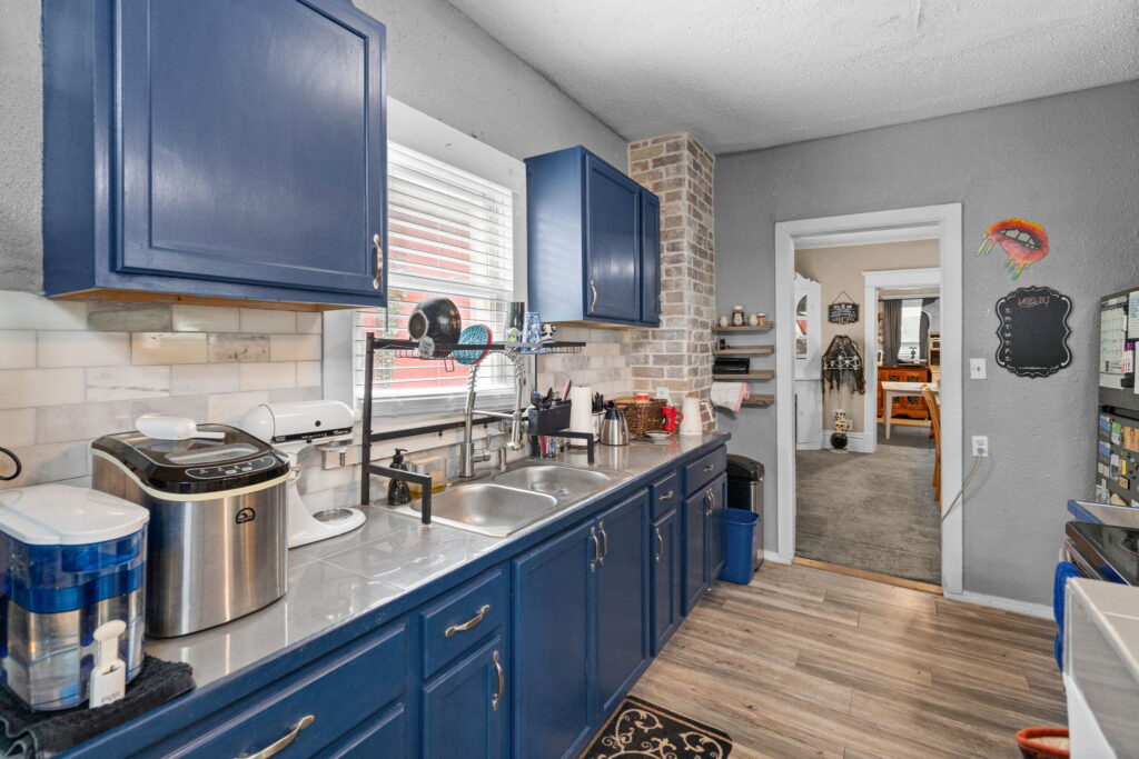 Kitchen sink under a window with navy blue cabinets in a Kansas City, Missouri home