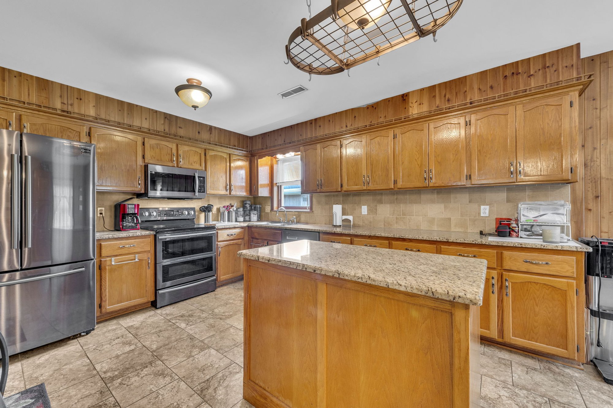 Kitchen island with granite counters at 111 Cora Drive, Weston, MO