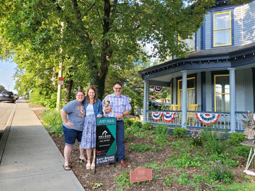 Kiera, Jerry and Katy Gaines with the Nelson Home Group sold sign in front of the Firefly Inn, 908 Washington Street, Weston, MO