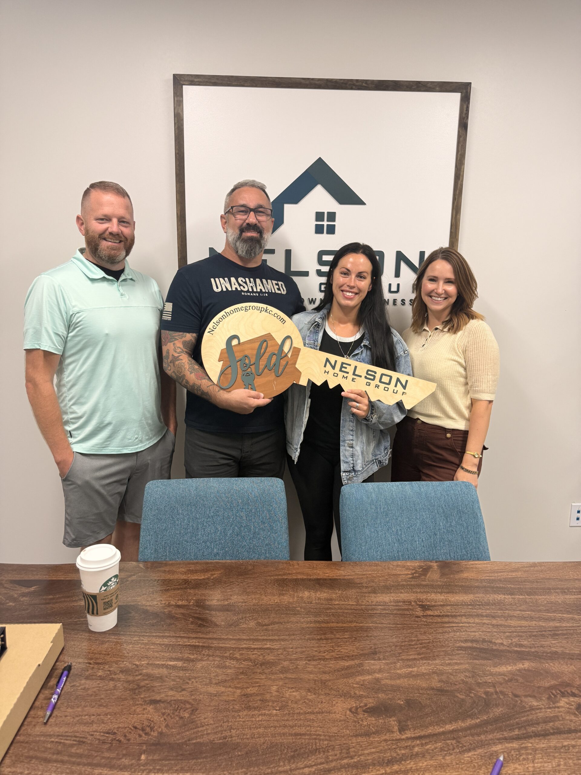 Joe Nelson, Richard, Amberlie and Katy Gaines with the Nelson Home Group sold key at closing on 19204 Corbyn Lane, Smithville, MO