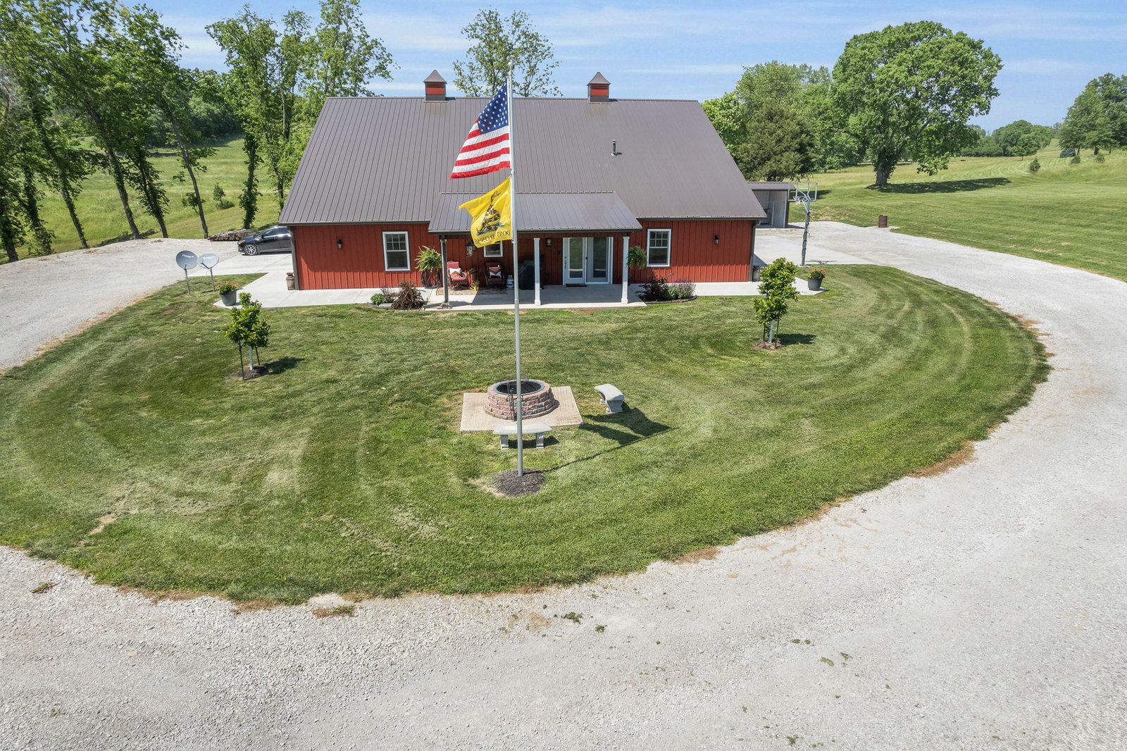 Aerial view of the red barndominium at 27900 E Dye Store Road in Weston, Missouri, with its circle drive and flagpole
